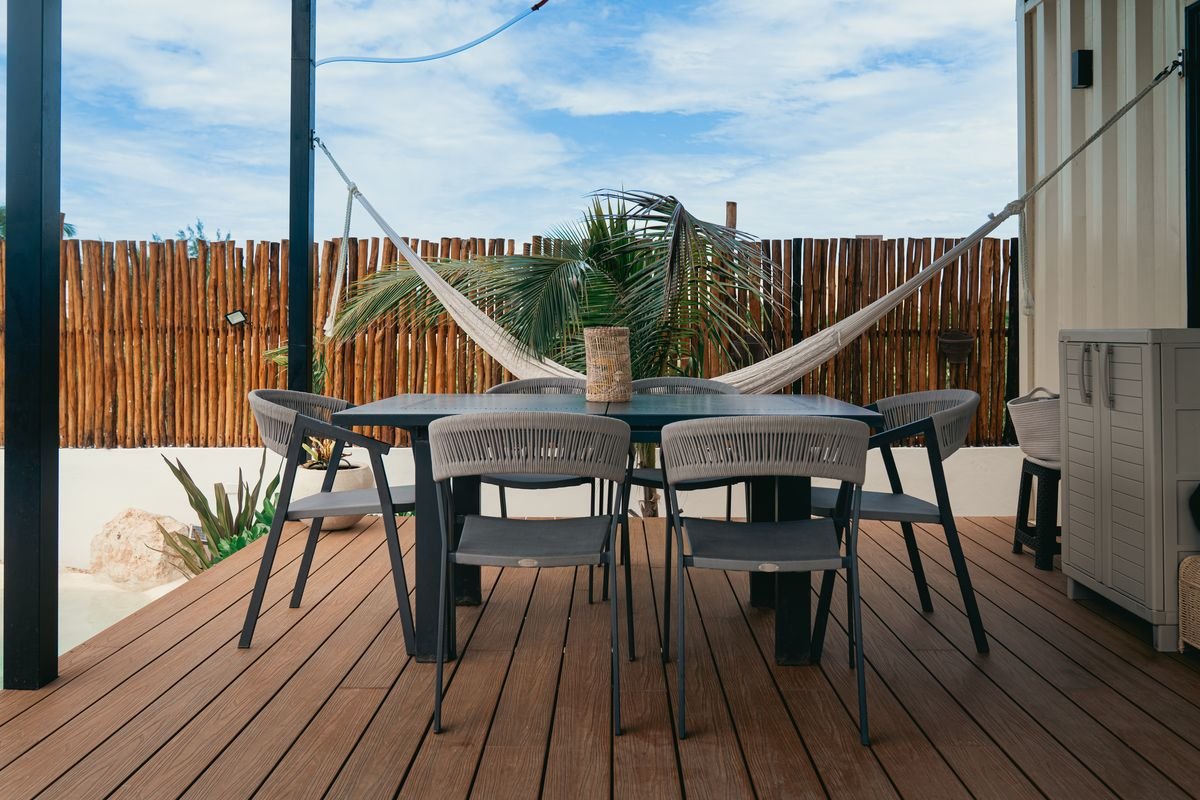 Comedor exterior en la terraza de madera con vista al mar