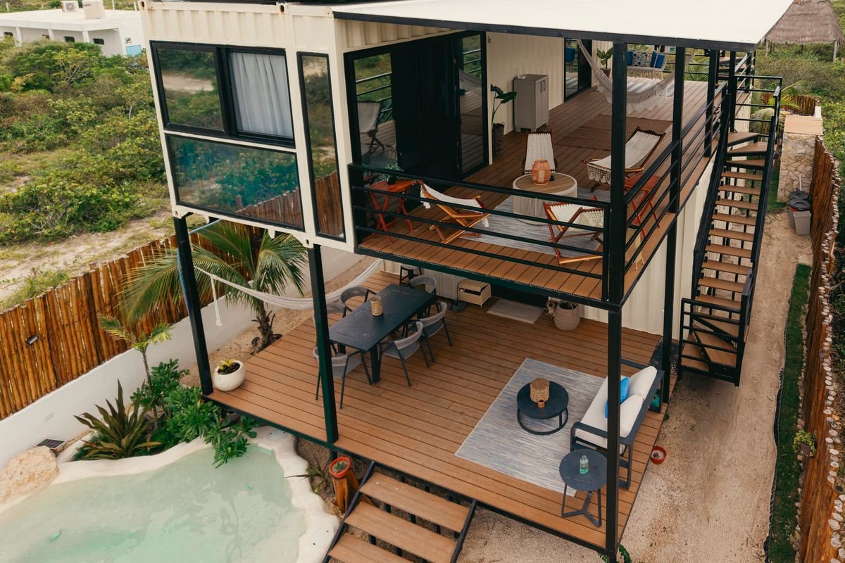 Fachada de arquitectura moderna tipo casa contenedor con grandes ventanales y terrazas