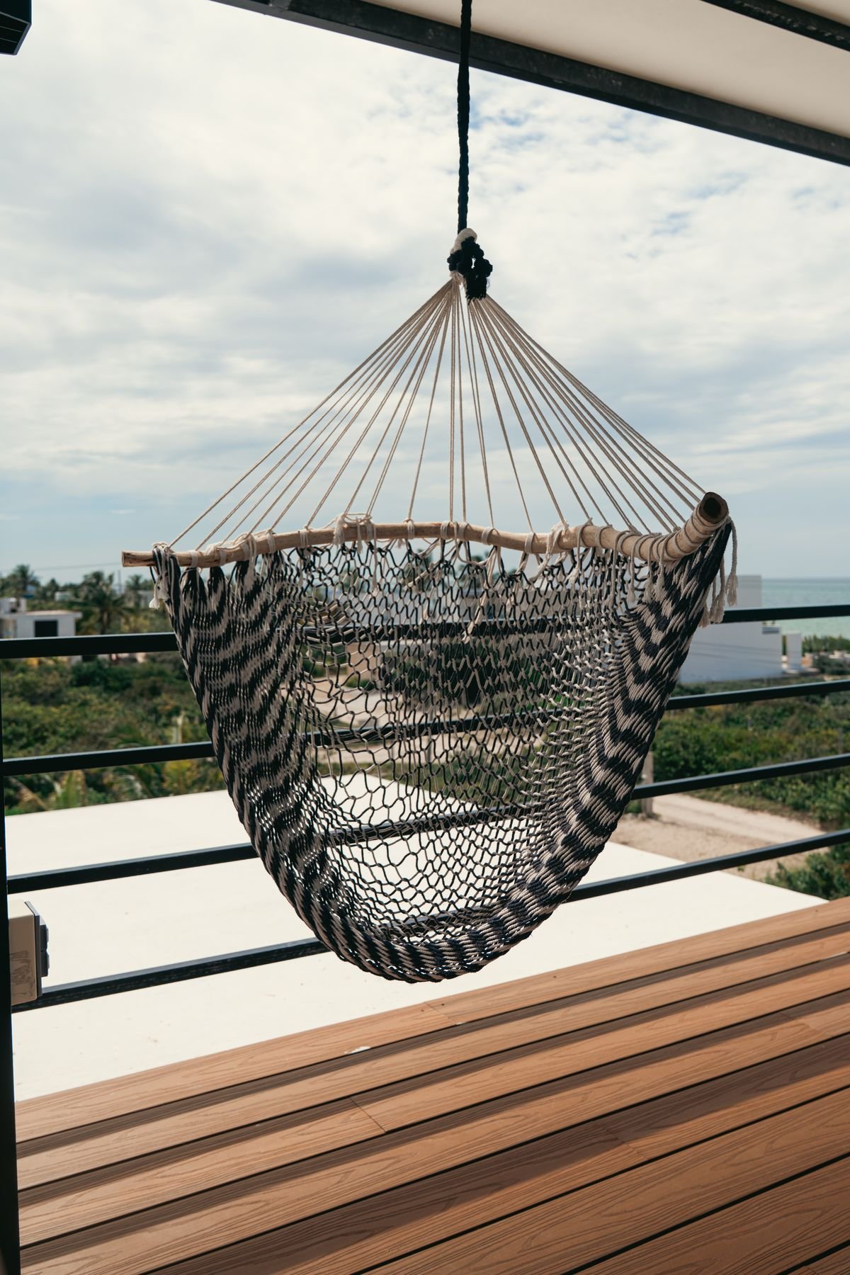 Silla colgante en la terraza con vista abierta al mar